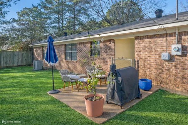 a view of a patio with table and chairs potted plants and a large tree