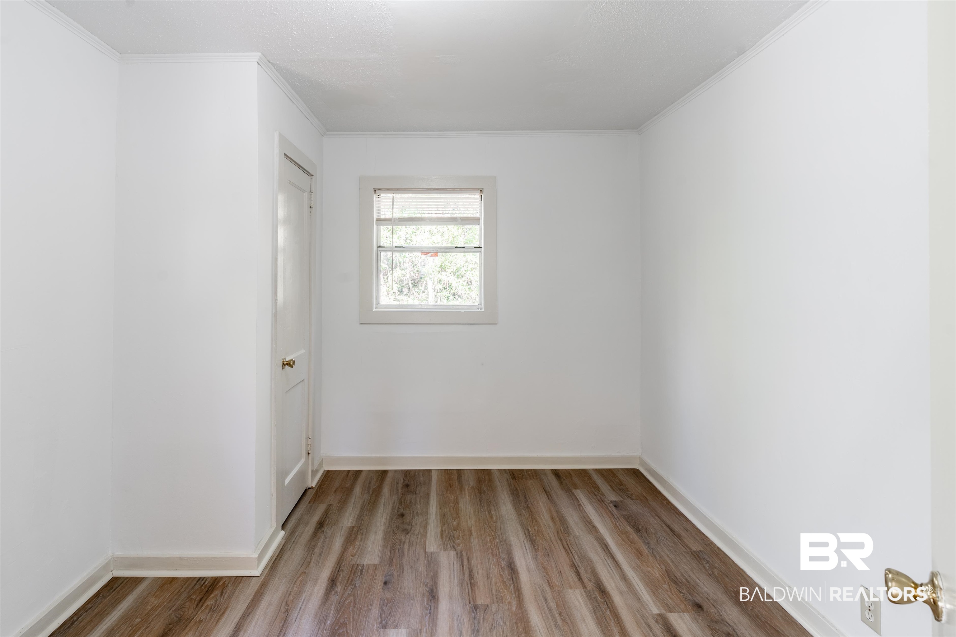 3900 Brookmont Drive Mobile, AL 36605 - Photo 10 of 19 Spare room featuring hardwood / wood-style floors and crown molding