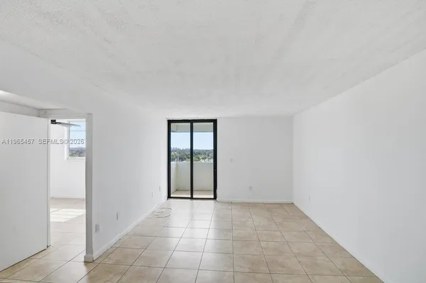 an empty room with sliding door and windows