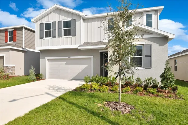 a front view of a house with a garden and plants