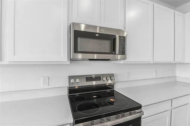 a kitchen with stainless steel appliances a stove a microwave and cabinets