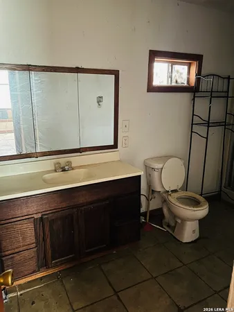 a bathroom with a toilet a sink and mirror