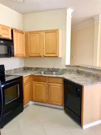 a kitchen with granite countertop cabinets stainless steel appliances and a sink