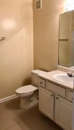 a bathroom with a granite countertop toilet and sink