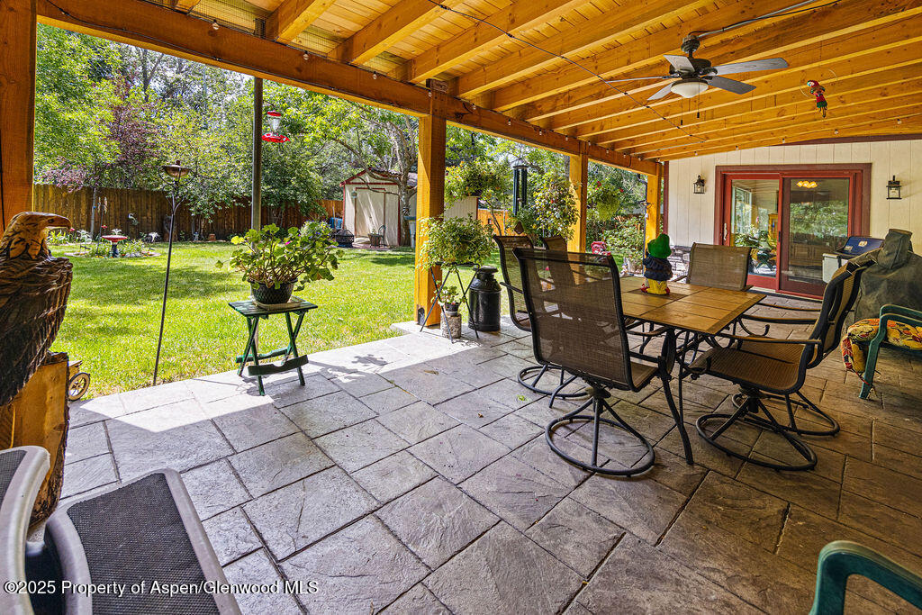 2928 Pinon Circle Craig, CO 81625 - Photo 73 of 92 a view of a patio with table and chairs potted plants and floor to ceiling window with wooden floor