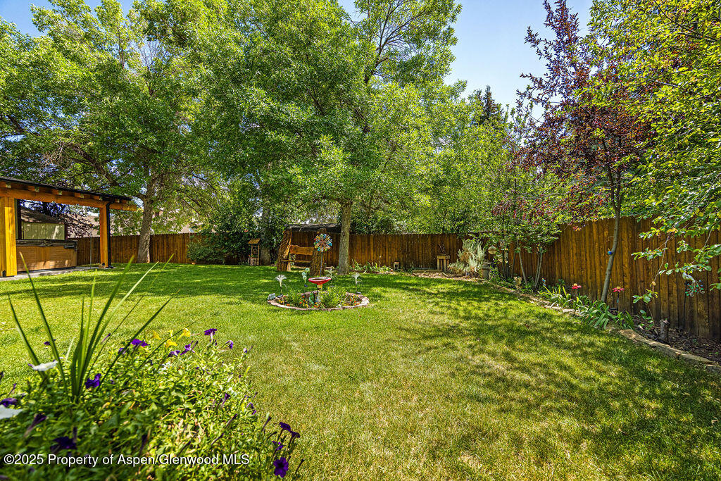 2928 Pinon Circle Craig, CO 81625 - Photo 90 of 92 a view of a backyard with table and chairs and potted plants and large trees