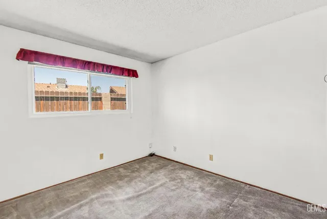 an empty room with a chandelier fan