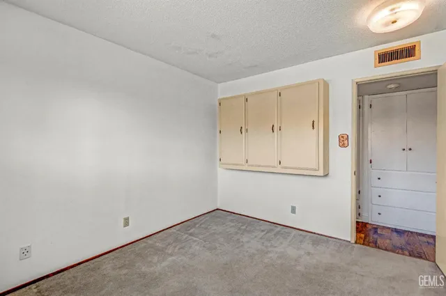 an empty room with a window and a ceiling fan