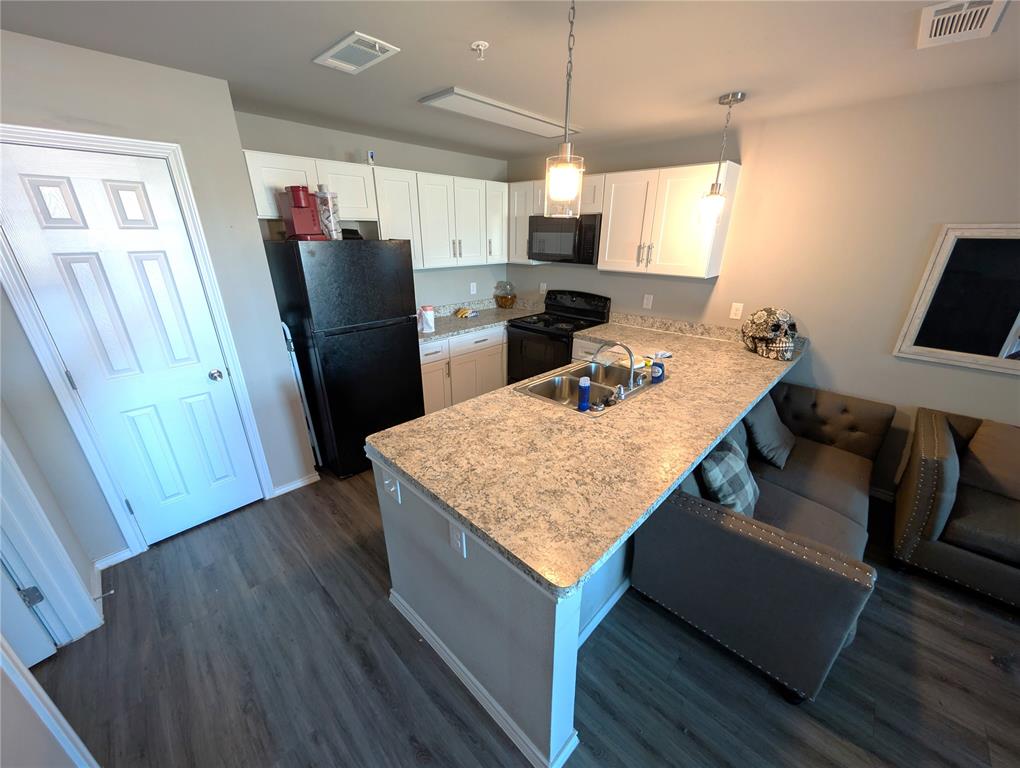 6108 Abrams Road, Unit 202 Dallas, TX 75231 - Photo 4 of 5 a kitchen with refrigerator cabinets and wooden floor