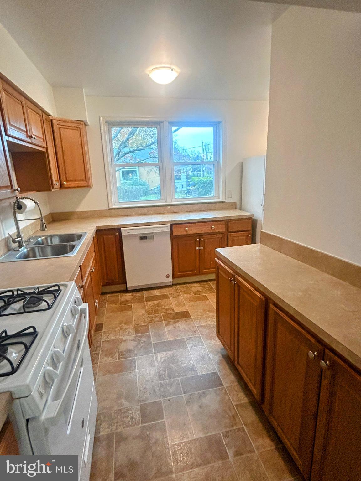 787 Pennsylvania Avenue Wallingford, PA 19086 - Photo 14 of 26 a view of a kitchen with kitchen island a sink wooden floor and a stove