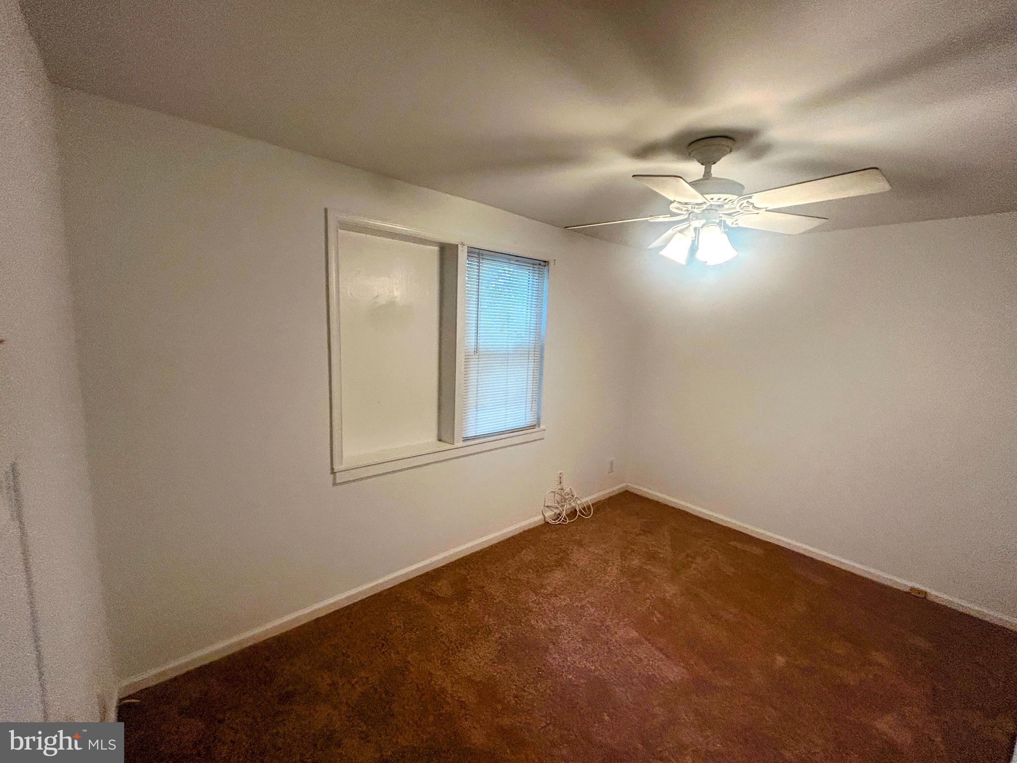 787 Pennsylvania Avenue Wallingford, PA 19086 - Photo 21 of 26 an empty room with a chandelier fan and windows