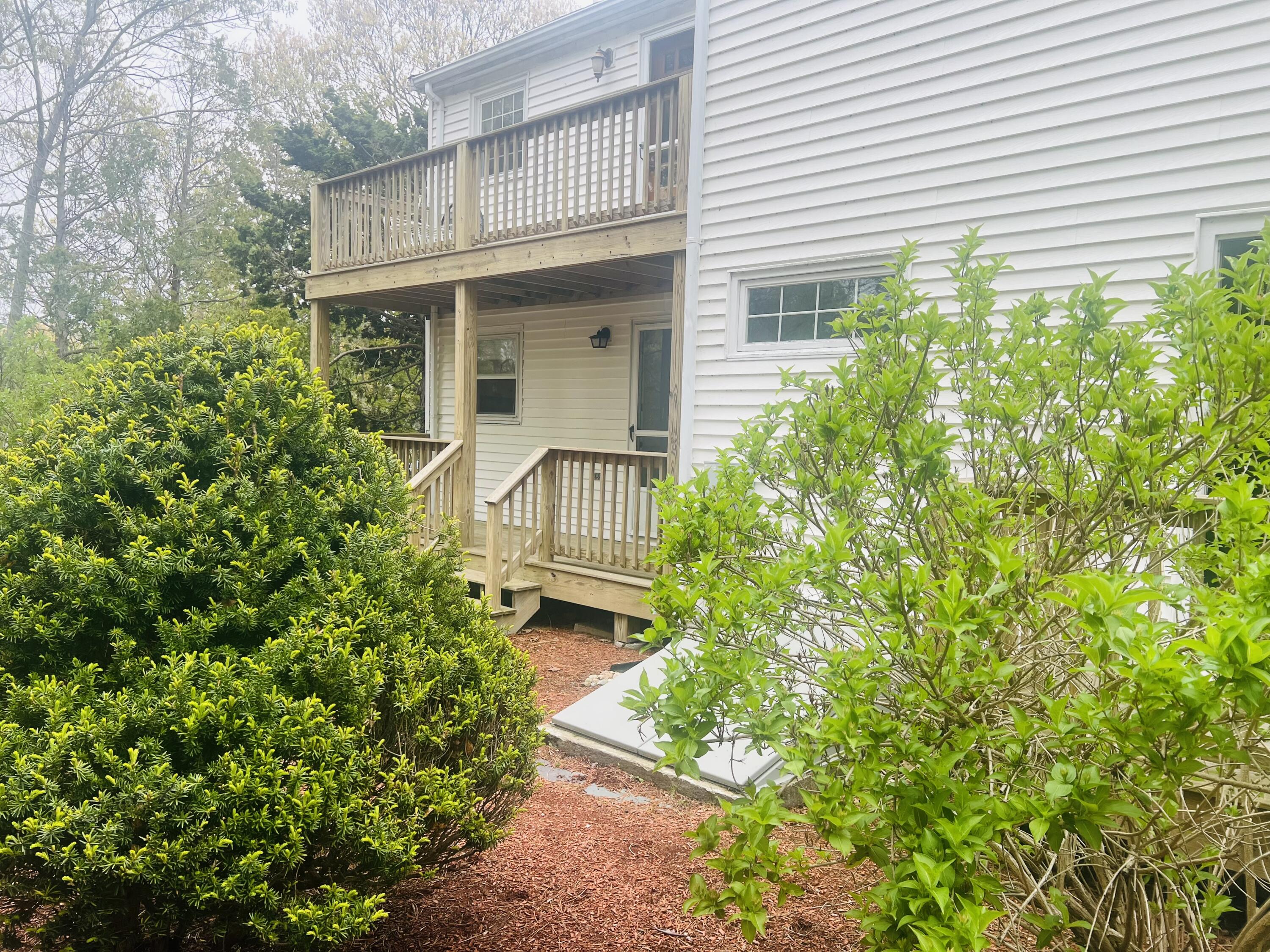 1431 Iyannough Road, Unit 1 Centerville, MA 02632 - Photo 2 of 28 a front view of a house with a yard
