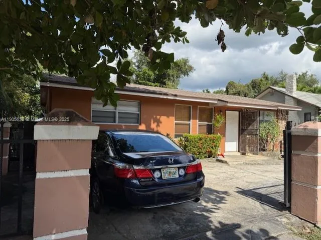 a front view of a house with a yard and potted plants