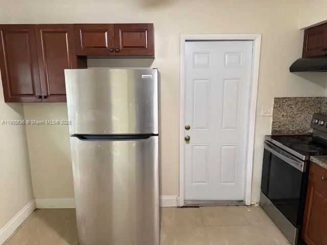 a white refrigerator freezer and a stove sitting inside of a kitchen