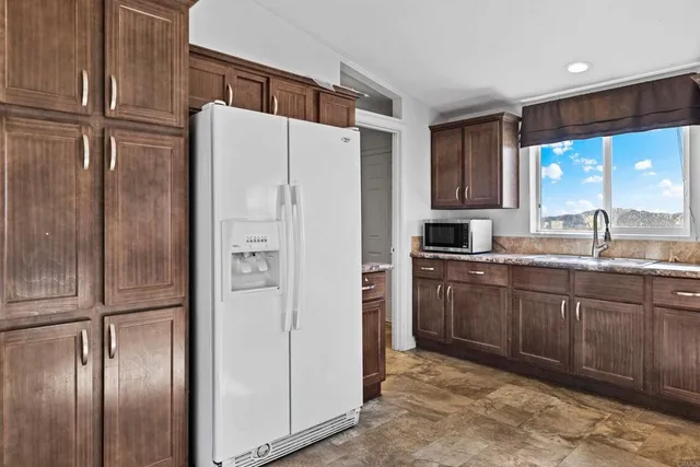 a kitchen with stainless steel appliances granite countertop a refrigerator and a sink