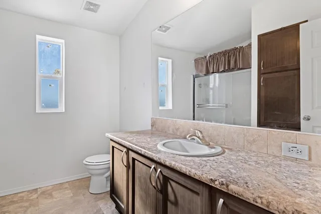 a bathroom with a granite countertop sink toilet and shower