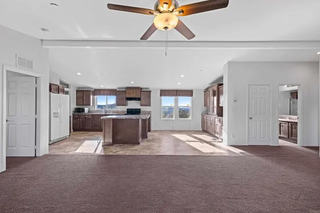 a view of a kitchen with a refrigerator and a stove top oven
