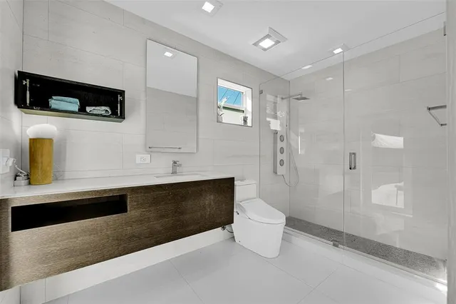 a bathroom with a sink a toilet and shower