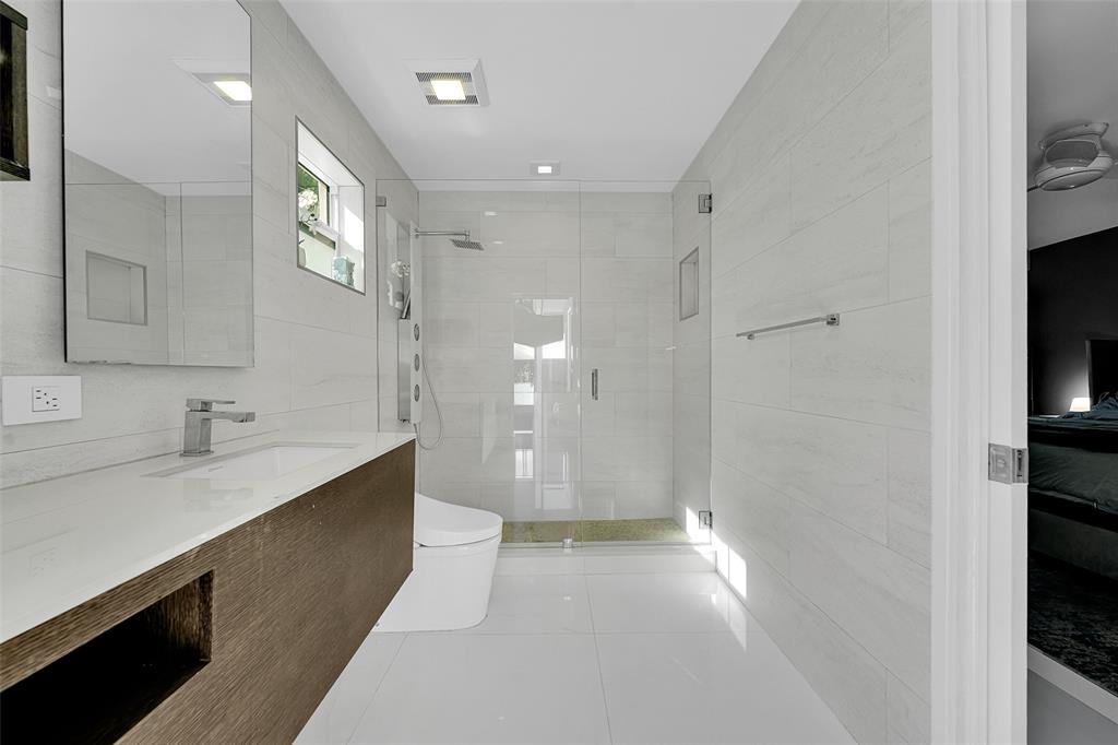 640 Northwest 30th Street Wilton Manors, FL 33311 - Photo 17 of 25 a bathroom with a sink a toilet and a large mirror