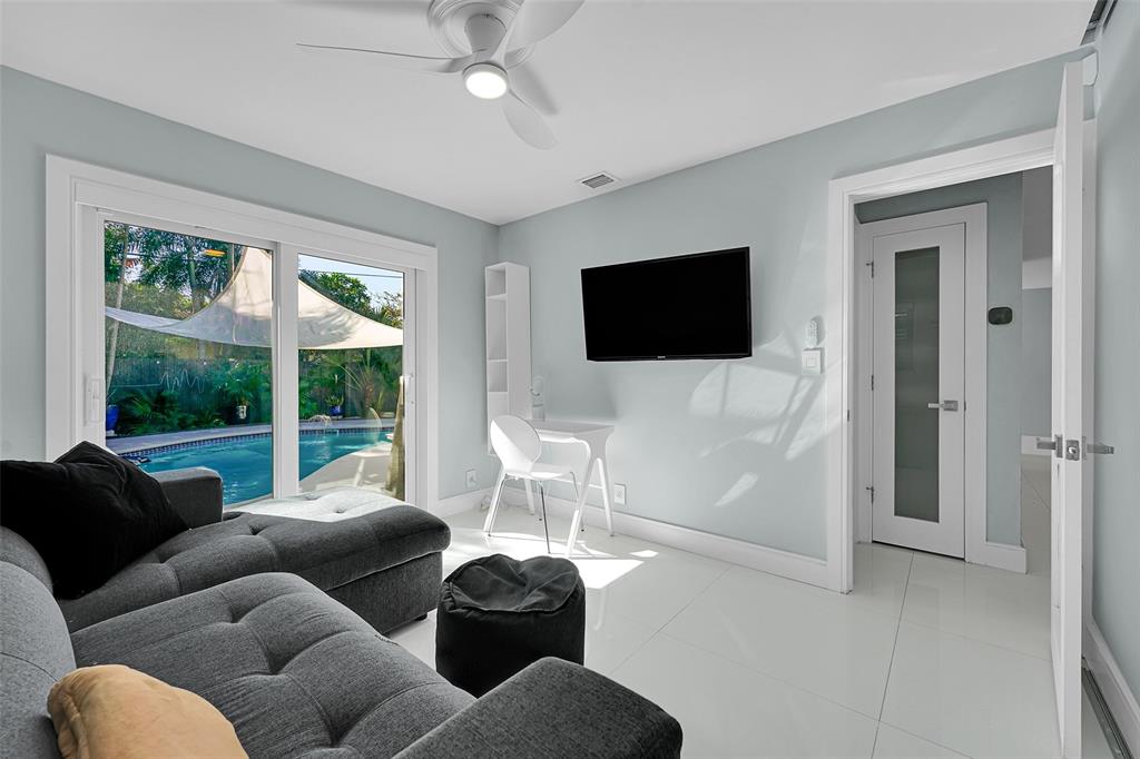 640 Northwest 30th Street Wilton Manors, FL 33311 - Photo 4 of 25 a living room with furniture a flat screen tv and a large window