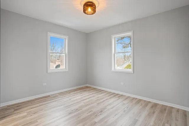 a view of a room with wooden floor and windows