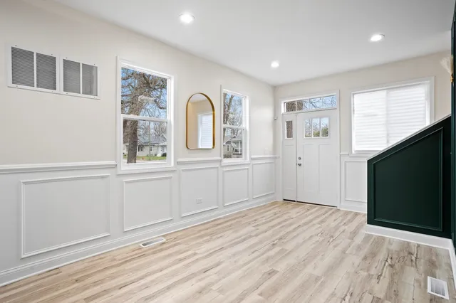 a view of empty room with window and wooden floor