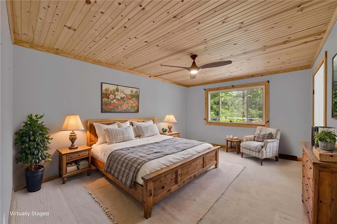 433 Latham Road Easley, SC 29640 - Photo 34 of 50 A rustic primary bedroom features wood plank ceilings, a comfortable sitting area, and ample natural light.