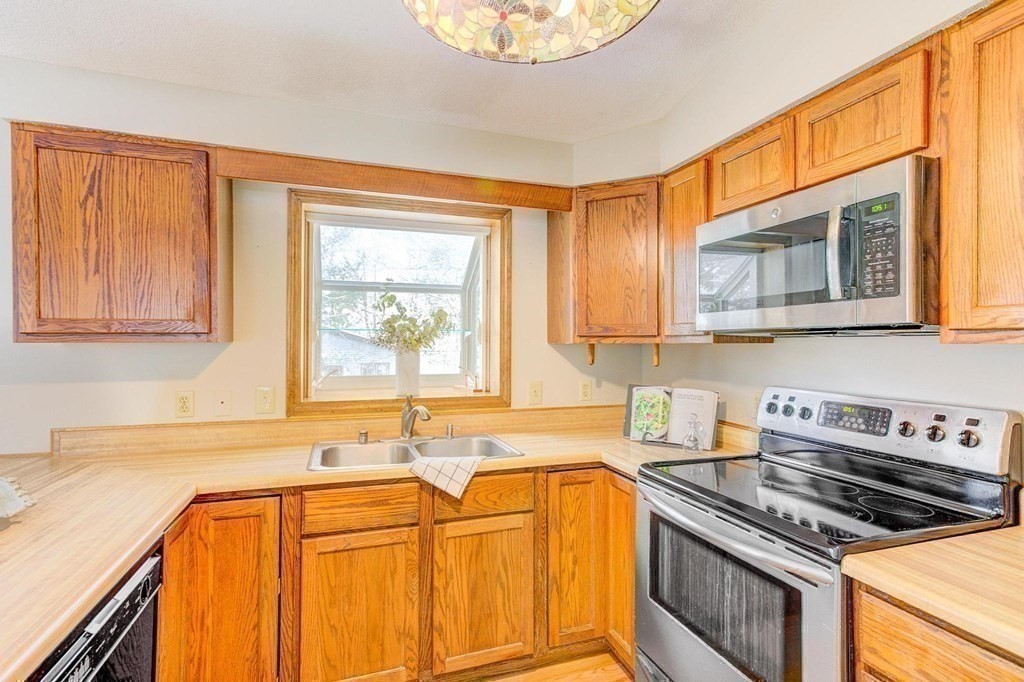 68 Dothan Street Arlington, MA 02474 - Photo 9 of 42 a kitchen with stainless steel appliances granite countertop a stove a sink and a microwave