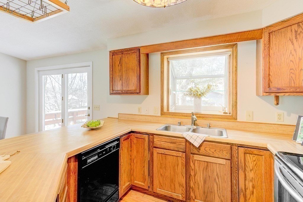 68 Dothan Street Arlington, MA 02474 - Photo 10 of 42 a kitchen with stainless steel appliances a sink a stove cabinets and a window