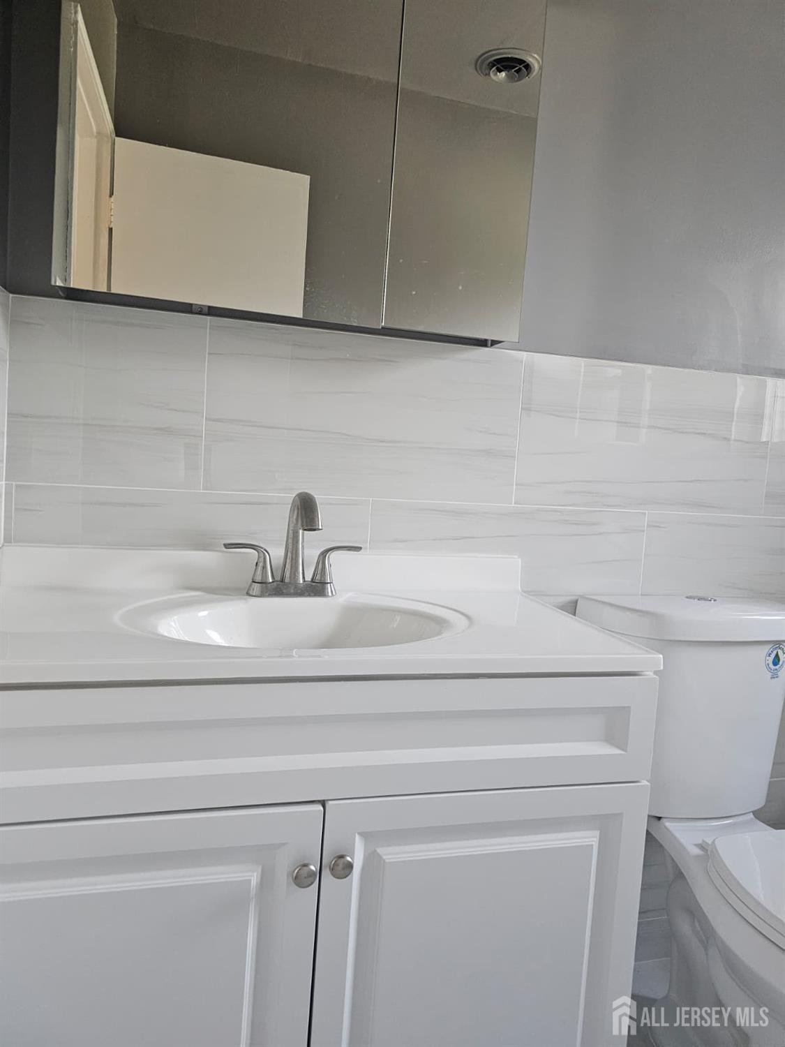 57 Judson Street, Unit 9A Edison, NJ 08837 - Photo 8 of 13 a bathroom with a sink a toilet and vanity