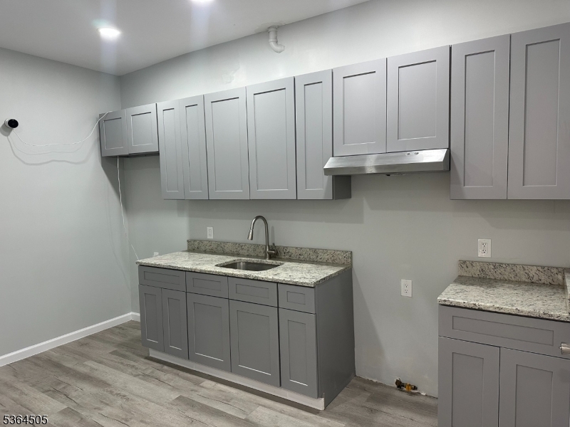 676 East 24th Street Paterson, NJ 07504 - Photo 3 of 12 a kitchen with stainless steel appliances granite countertop a sink and cabinets
