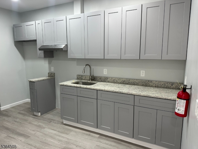 676 East 24th Street Paterson, NJ 07504 - Photo 6 of 12 a kitchen with stainless steel appliances granite countertop a sink a refrigerator and a white cabinets