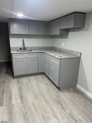 a kitchen with granite countertop a sink and cabinets