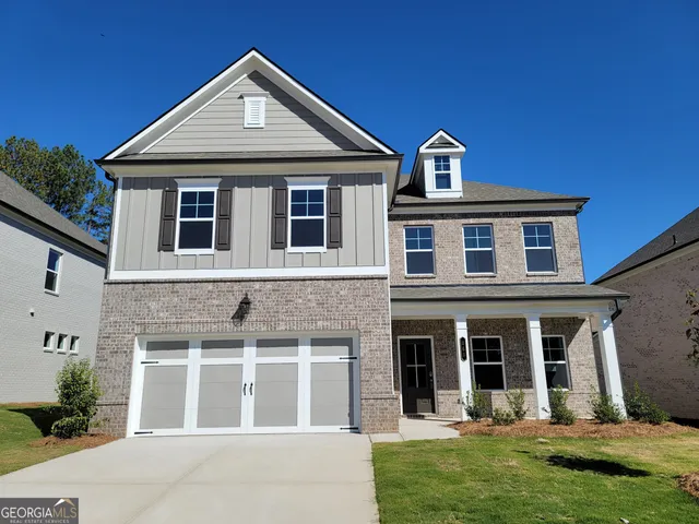 a front view of a house with a yard and garage