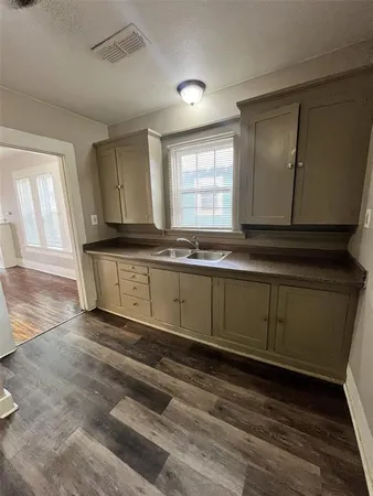 a kitchen with granite countertop a sink and cabinets