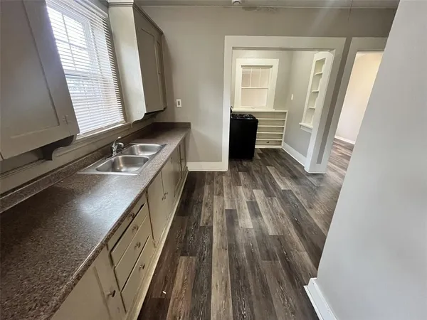 a kitchen with wooden floors and sink