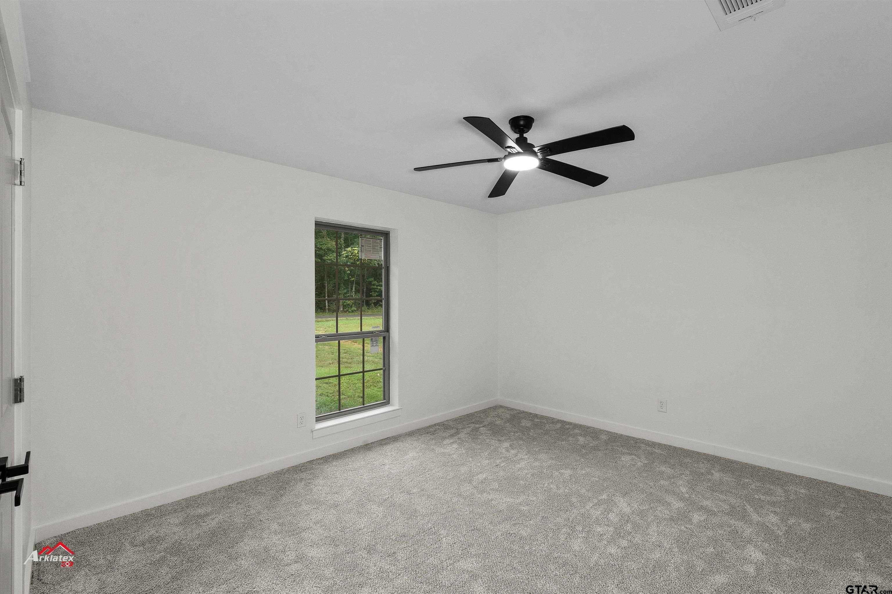 875 Old Town Road Marshall, TX 75672 - Photo 25 of 34 an empty room with a window and a fan