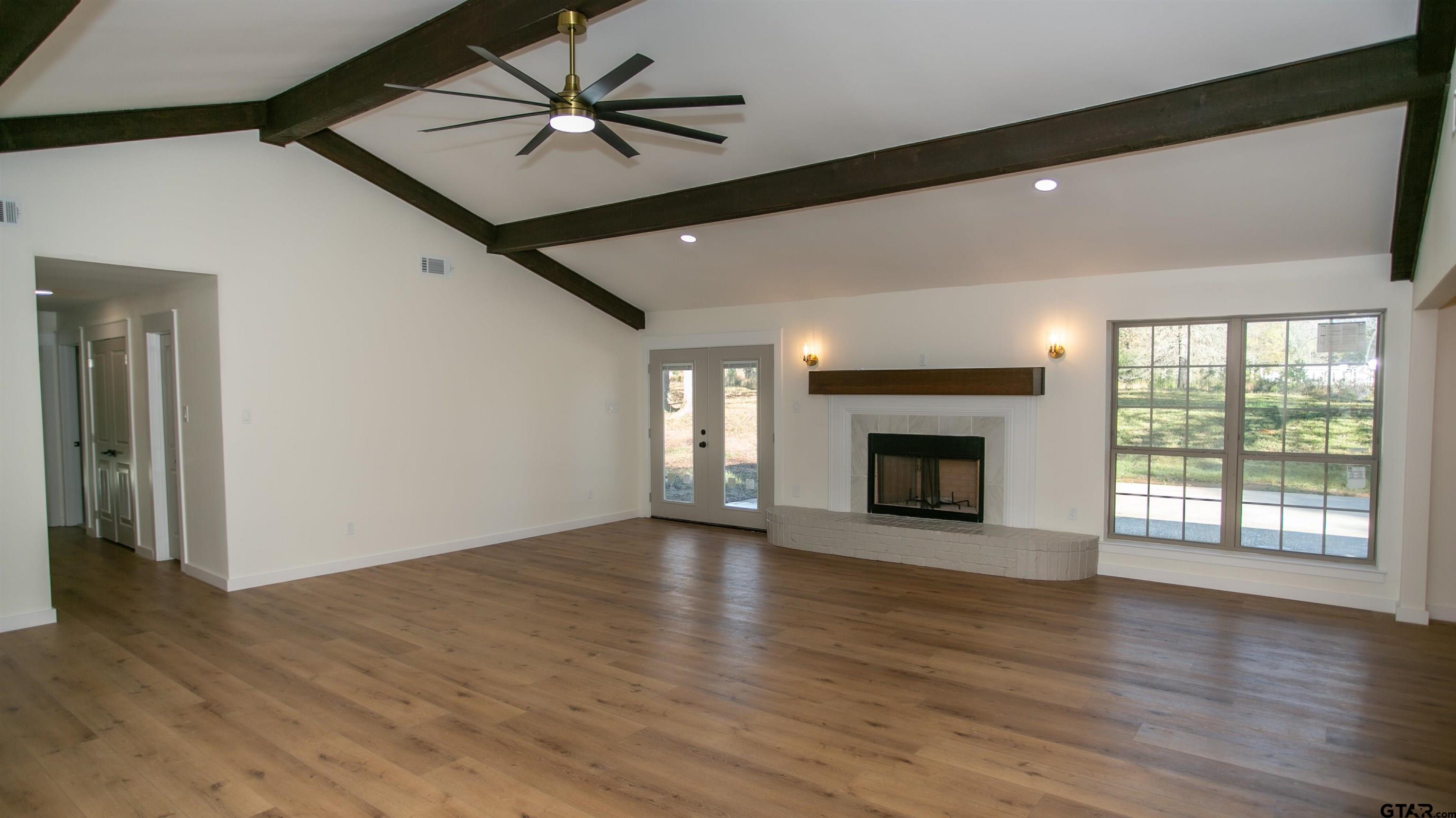 875 Old Town Road Marshall, TX 75672 - Photo 7 of 34 a view of an empty room with wooden floor fireplace and a window