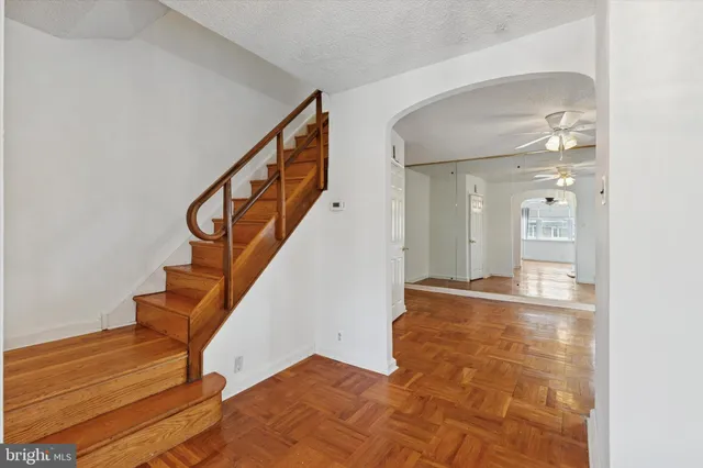 a view of a hallway with wooden floor and staircase