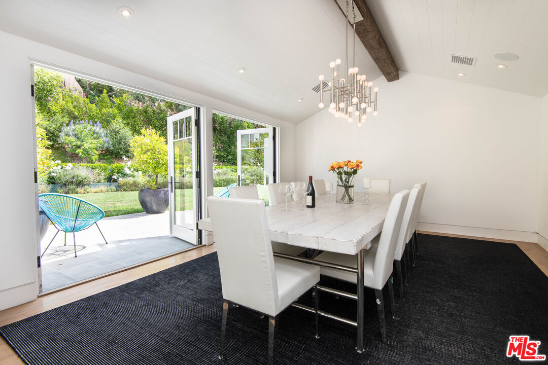 13705 Romany Drive Pacific Palisades, CA 90272 - Photo 14 of 54 a view of a dining room with furniture a chandelier and wooden floor