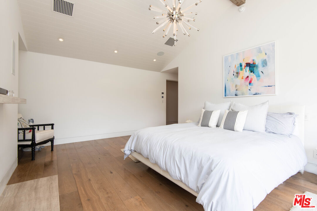 13705 Romany Drive Pacific Palisades, CA 90272 - Photo 23 of 54 a bedroom with a bed and a chandelier