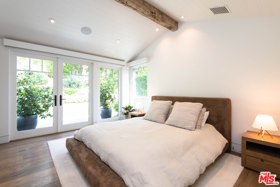 13705 Romany Drive Pacific Palisades, CA 90272 - Photo 35 of 54 a bedroom with a large bed and a large window with outer view