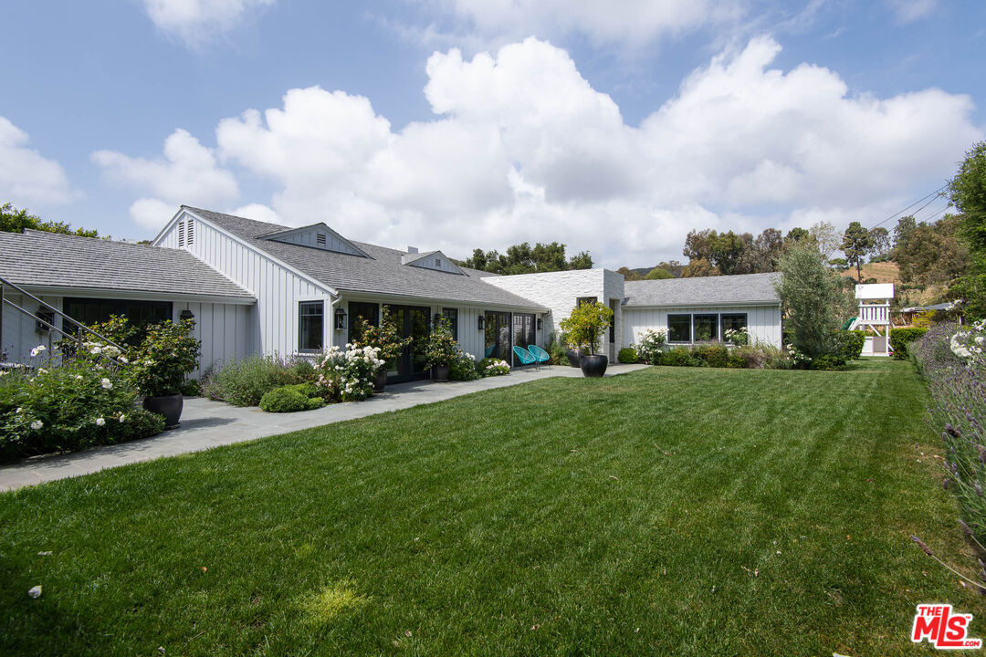 13705 Romany Drive Pacific Palisades, CA 90272 - Photo 39 of 54 a front view of a house with a garden and pathway