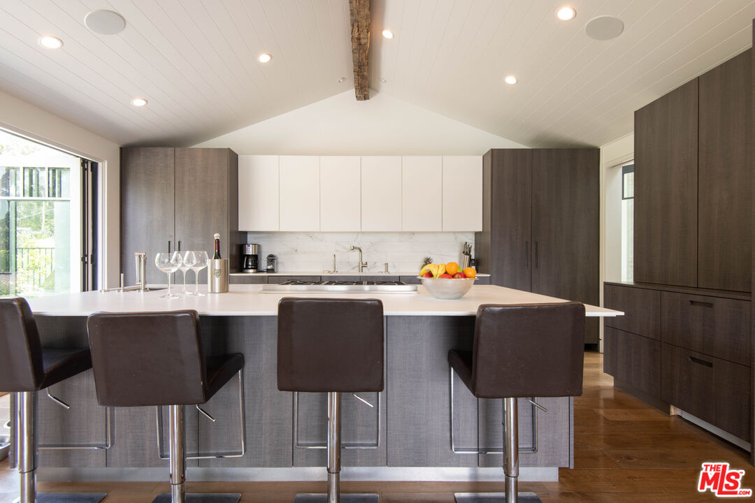 13705 Romany Drive Pacific Palisades, CA 90272 - Photo 9 of 54 a kitchen with stainless steel appliances granite countertop a dining table chairs and granite counter tops