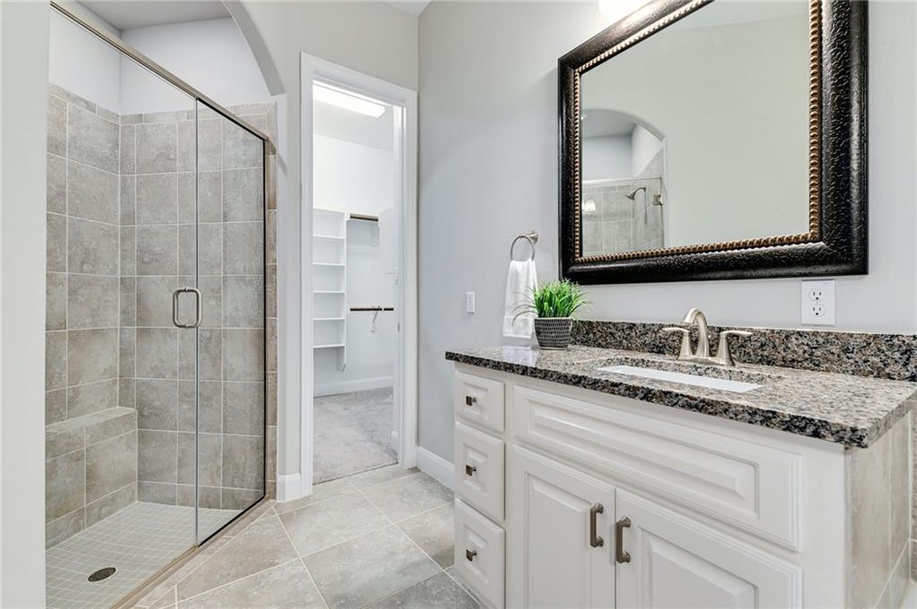 204 Maxwell Way, Unit 39 Austin, TX 78738 - Photo 16 of 26 a bathroom with a granite countertop sink a mirror and shower