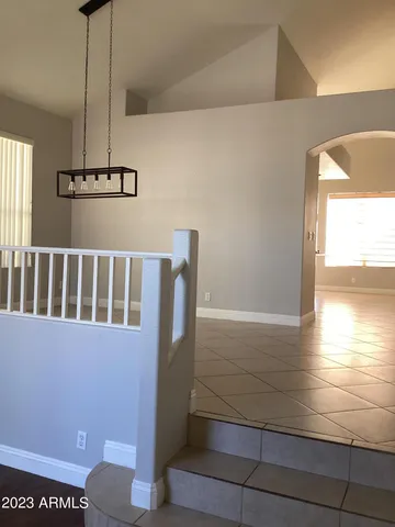 a view of a hallway with an empty room and wooden floor