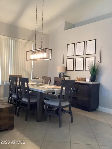 a room with a table chairs and kitchen appliances