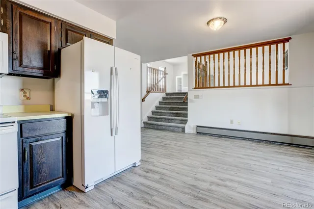 a view of a kitchen with wooden floor and electronic appliances