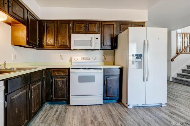 a kitchen with a refrigerator sink and cabinets
