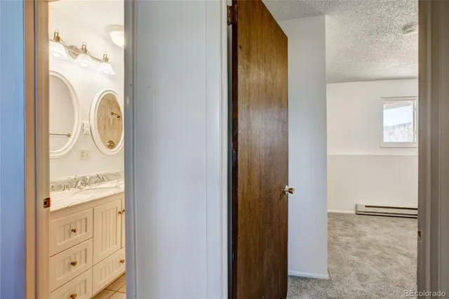 a bathroom with a granite countertop toilet a sink and a mirror